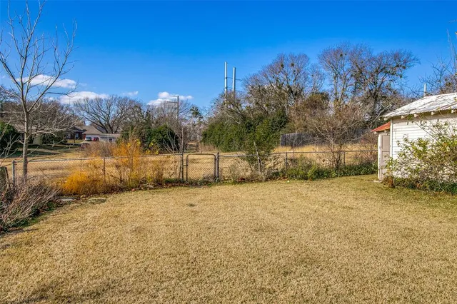 a view of dirt yard with a large tree