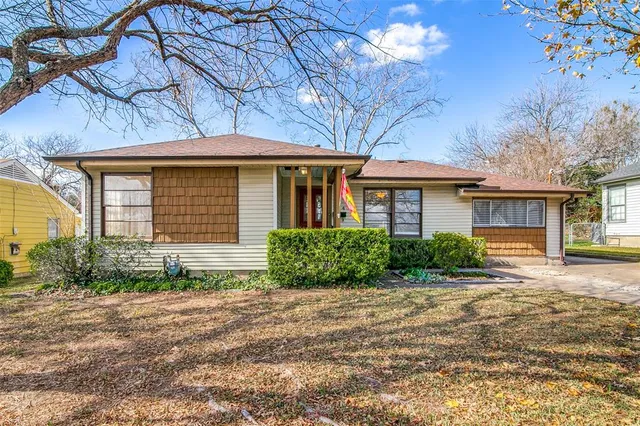 a front view of a house with a yard and potted plants