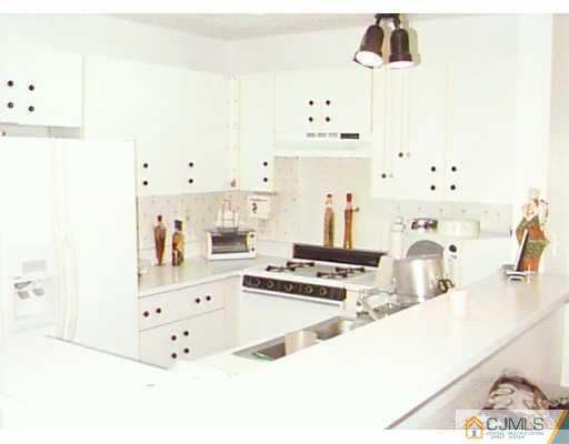 613 Edpas Road New Brunswick, NJ 08901 - Photo 5 of 7 a kitchen with kitchen island white cabinets and appliances