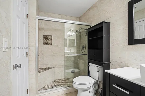 a bathroom with a shower toilet and sink