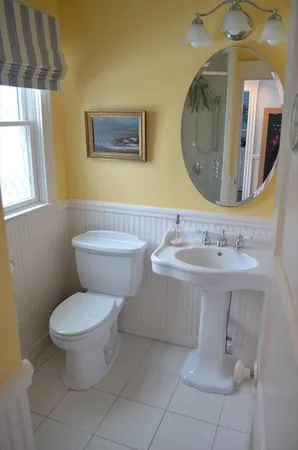 a bathroom with a toilet a sink and mirror
