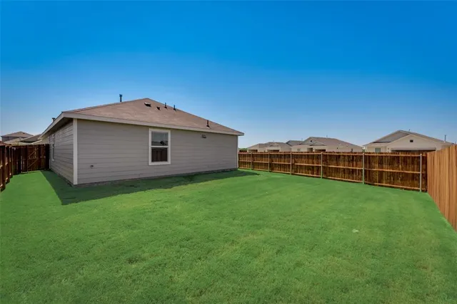 a view of a backyard with potted plants and wooden fence