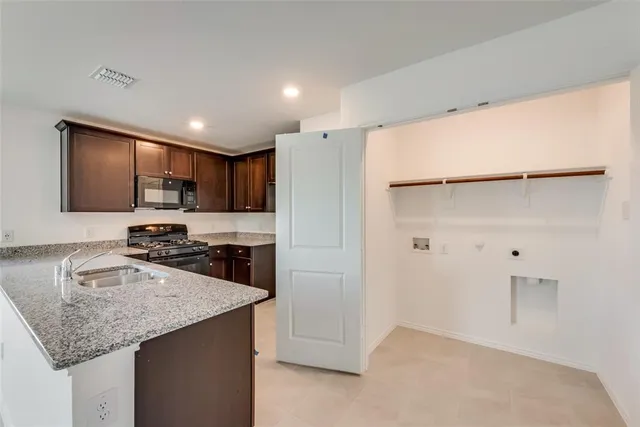 a kitchen with stainless steel appliances granite countertop a sink refrigerator and microwave