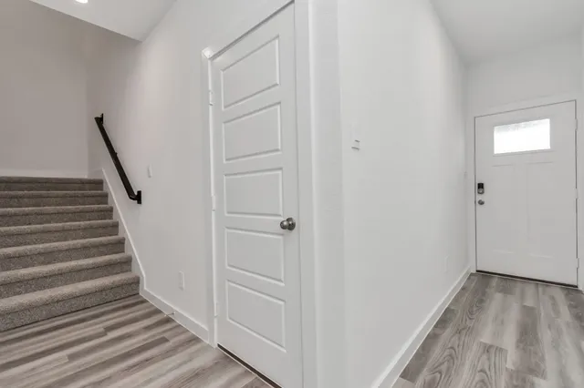 a view of a hallway with wooden floor and entryway