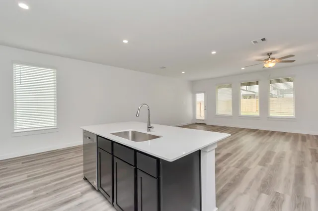 a kitchen with a sink cabinets and wooden floor