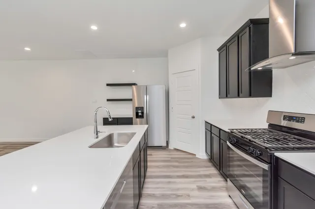 a kitchen with granite countertop a sink stove and refrigerator