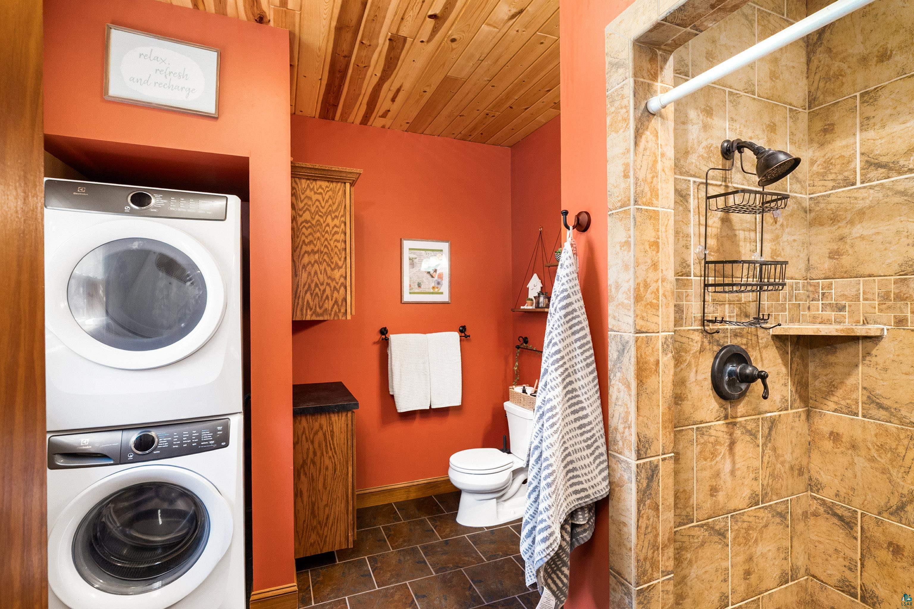 75 East Stark Road Esko, MN 55733 - Photo 25 of 87 Bathroom featuring a stacked laundry center, wood-finish ceiling, and orange wall paint