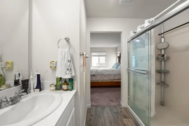 a bathroom with a tub shower vanity and a sink