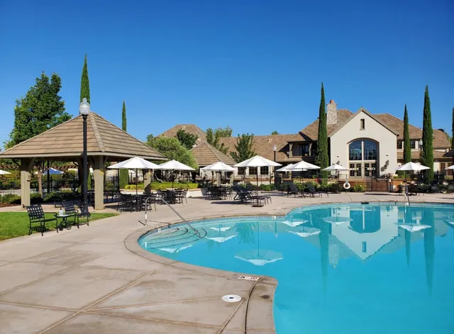 a front view of a house with swimming pool table and chairs