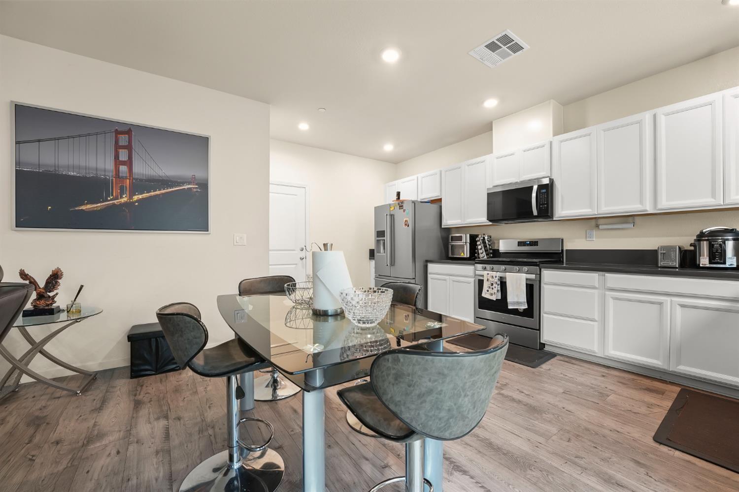 11789 Socrates Way Rancho Cordova, CA 95742 - Photo 3 of 23 a kitchen with stainless steel appliances granite countertop a stove a sink a dining table and chairs