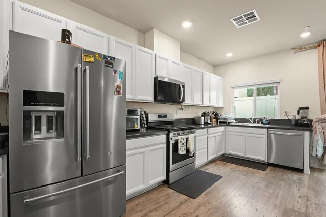 a kitchen with a refrigerator and a stove top oven