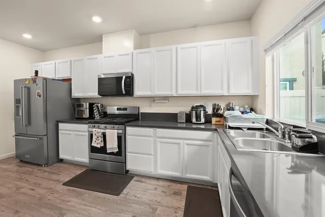 a kitchen with stainless steel appliances granite countertop a refrigerator sink and stove