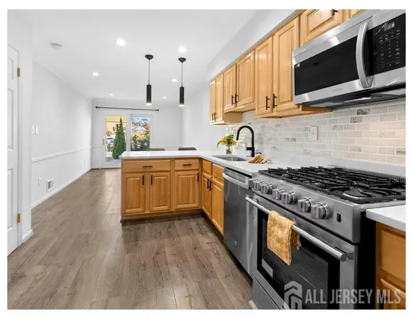 a kitchen with stainless steel appliances a stove a sink a microwave and cabinets