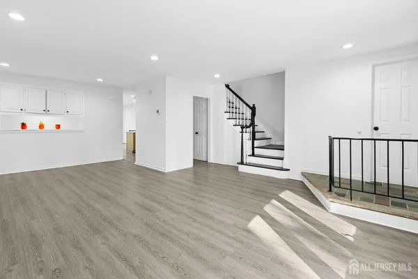 an empty room with wooden floor and entryway