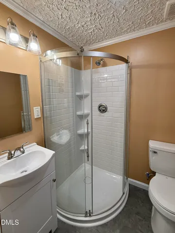a bathroom with a shower a toilet and sink