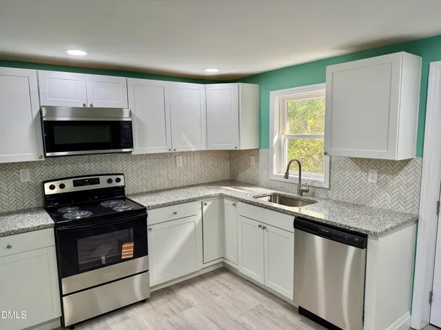 a kitchen with a sink stove and microwave