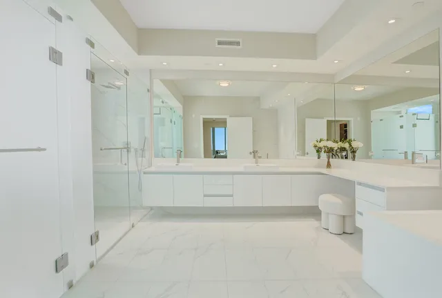 a bathroom with a double vanity sink mirror and bathtub