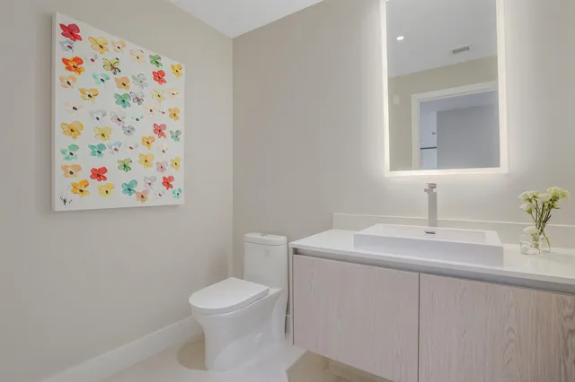 a bathroom with a toilet sink and mirror