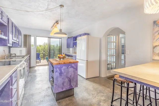a dining hall with stainless steel appliances granite countertop a stove and refrigerator