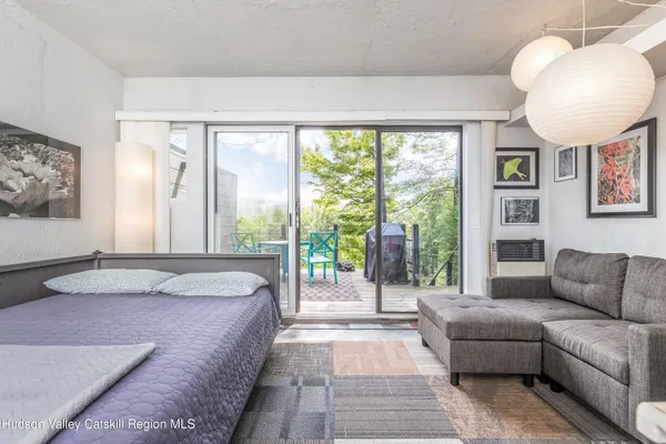 a spacious bedroom with a bed a couch and a large window