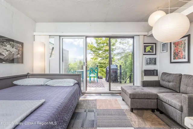 a spacious bedroom with a bed a couch and a large window