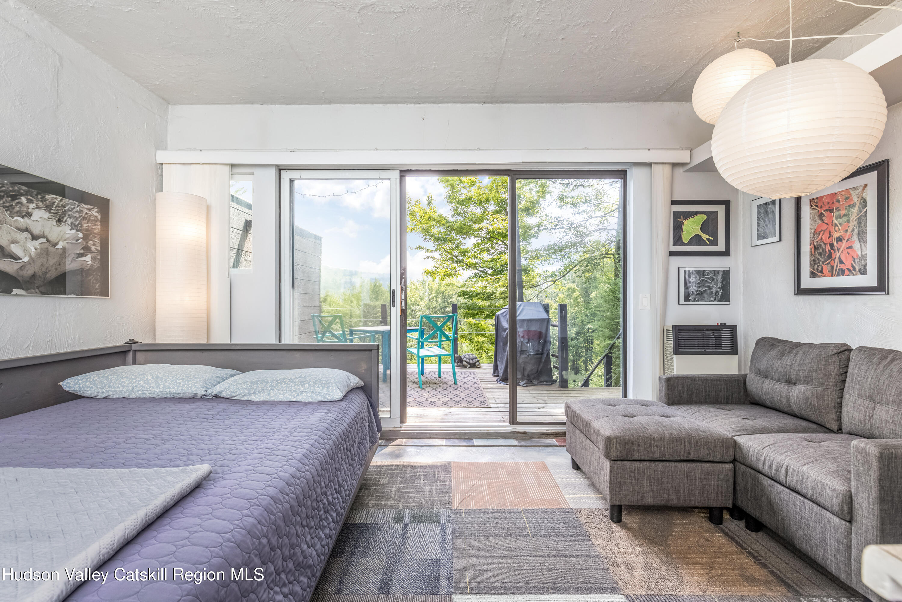 166 Todd Hill Road, Unit 166 West Kill, NY 12492 - Photo 23 of 42 a spacious bedroom with a bed a couch and a large window