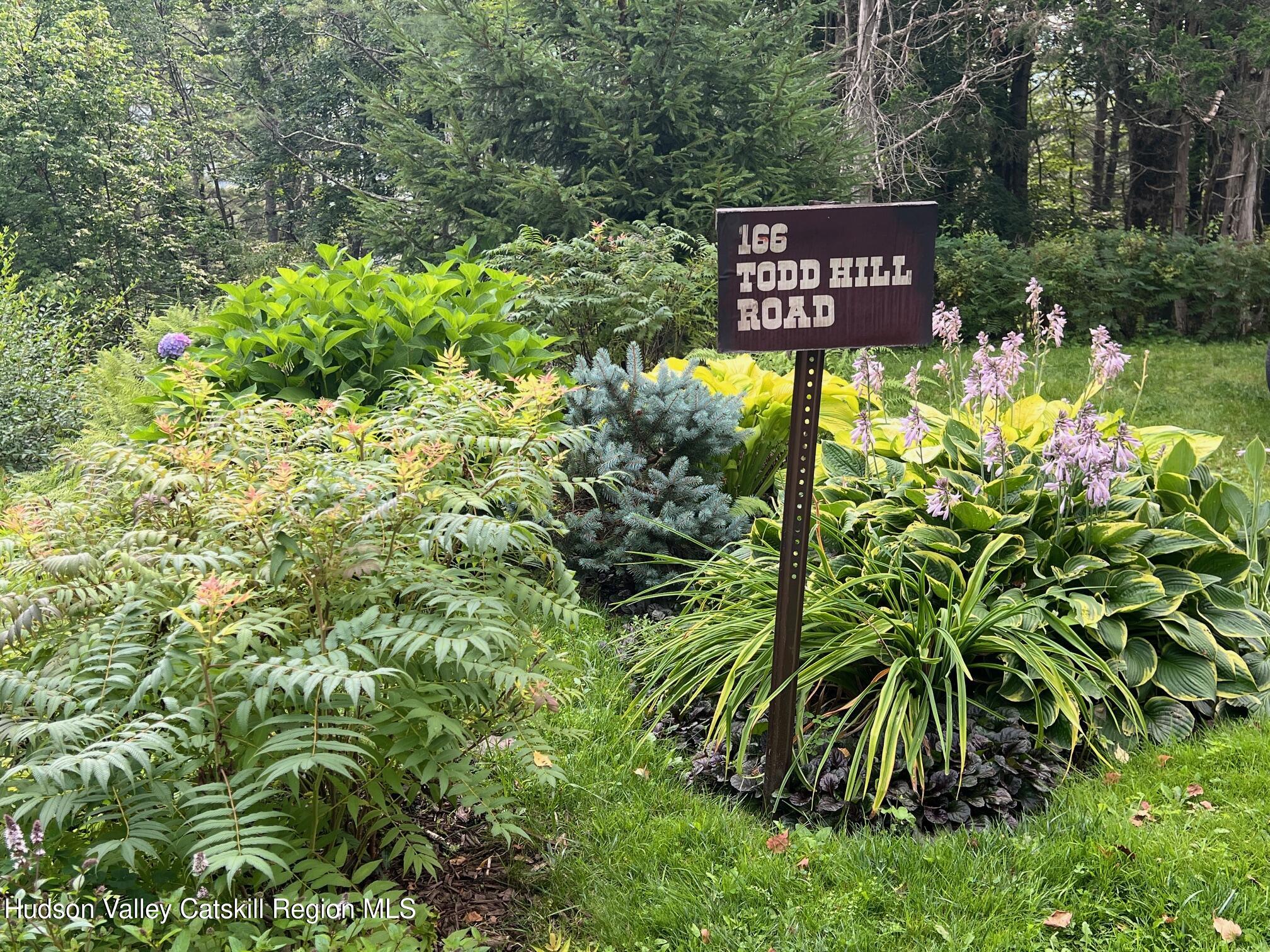 166 Todd Hill Road, Unit 166 West Kill, NY 12492 - Photo 4 of 42 a view of a sign in a garden
