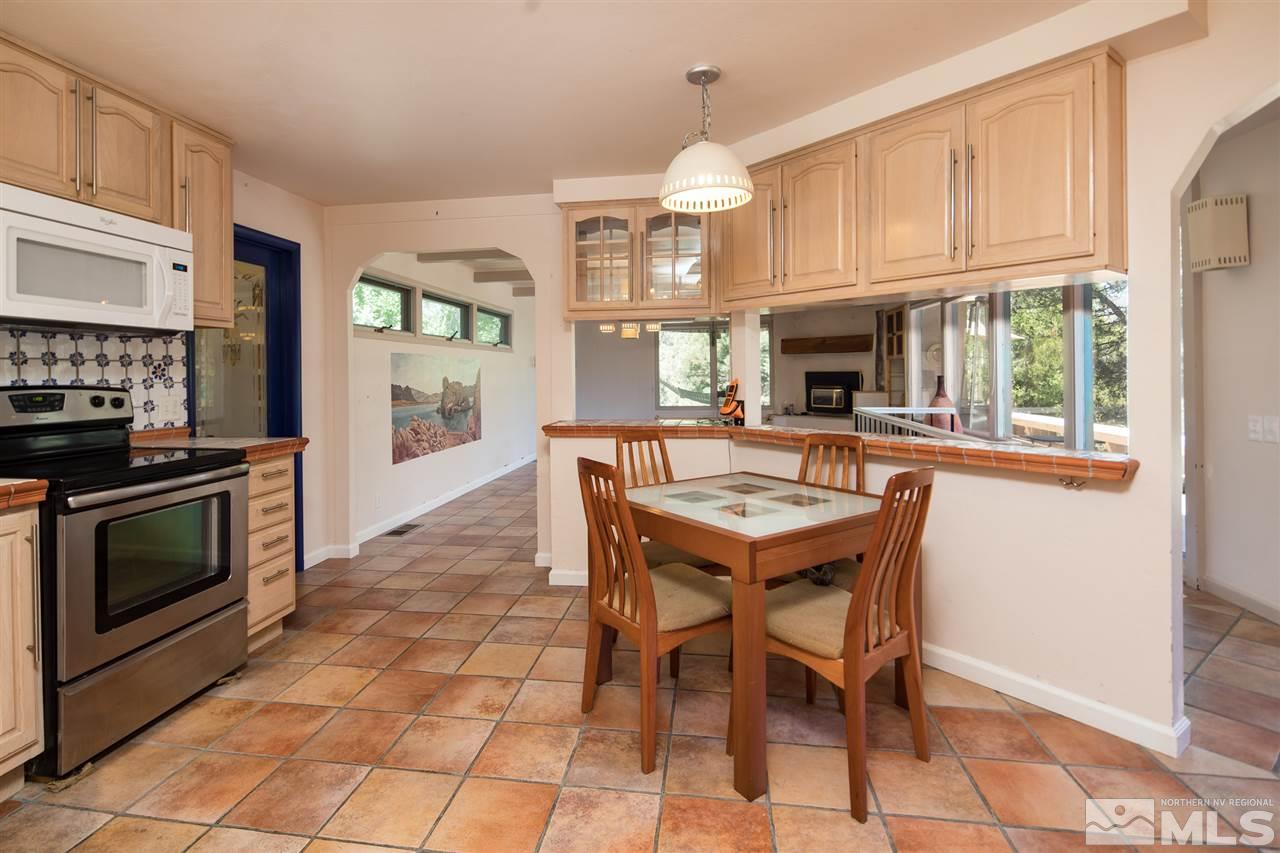 4321 Bridle Way Reno, NV 89519 - Photo 17 of 25 a kitchen with granite countertop a stove a sink dishwasher a dining table and chairs with wooden floor