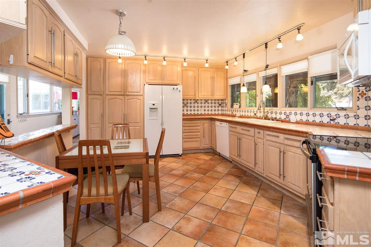 4321 Bridle Way Reno, NV 89519 - Photo 18 of 25 a kitchen with stainless steel appliances granite countertop a table chairs and a refrigerator