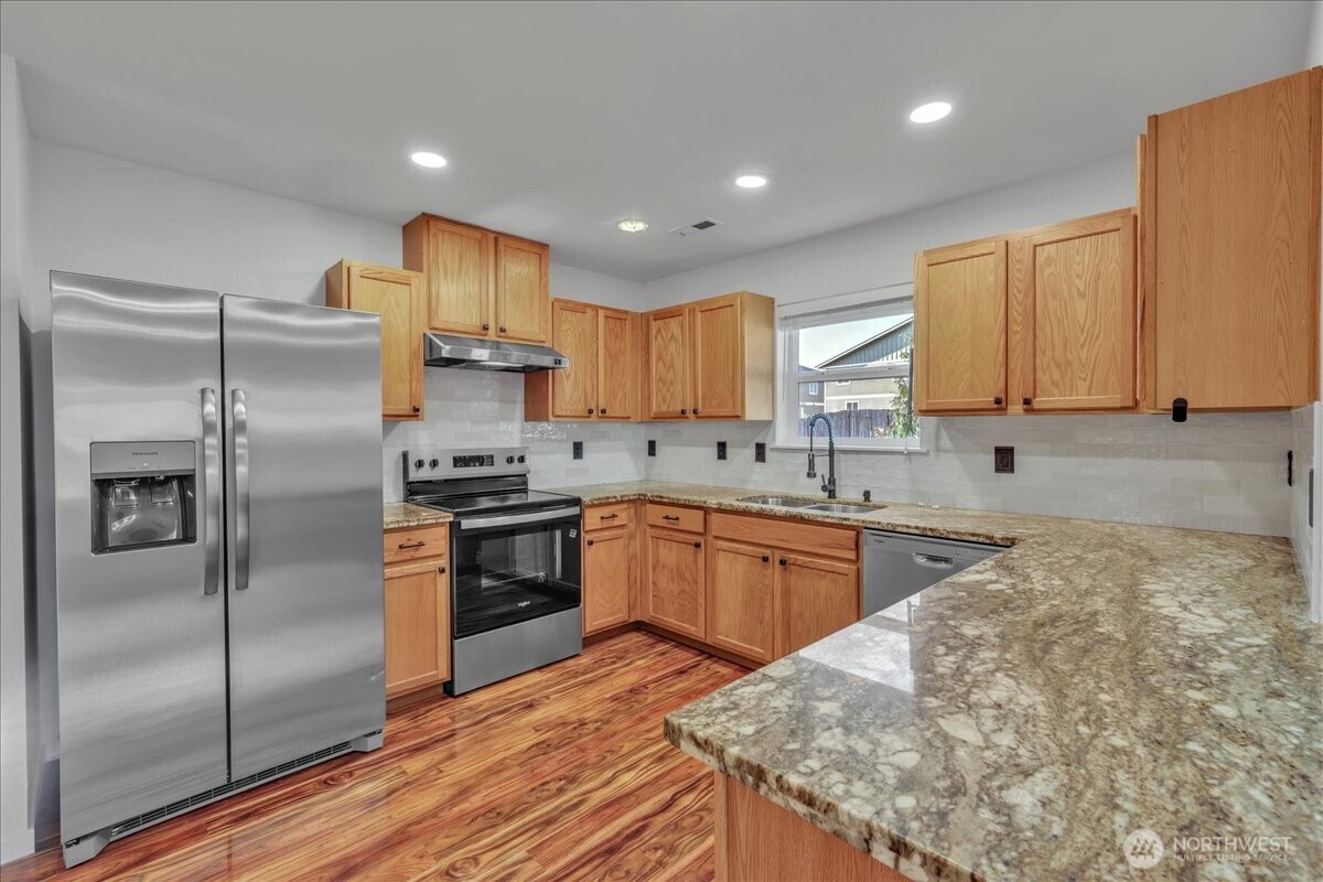 414 Easy Street Rainier, WA 98576 - Photo 27 of 38 a kitchen with granite countertop a refrigerator sink and microwave
