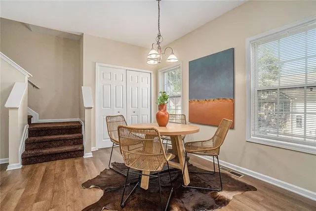a dining room with furniture a chandelier and wooden floor