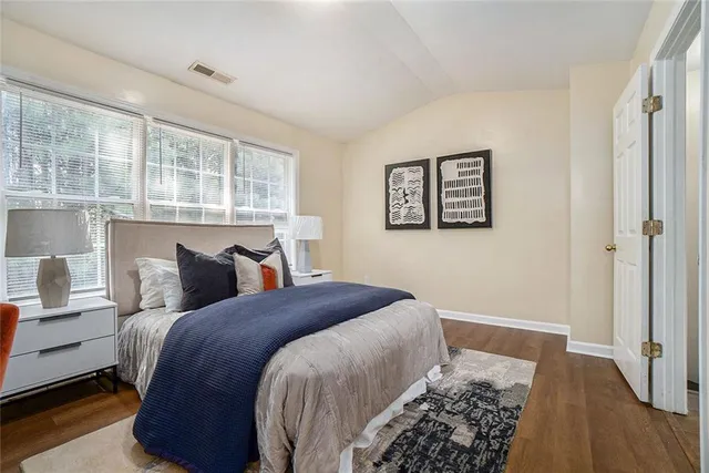 a bedroom with bed and wooden floor