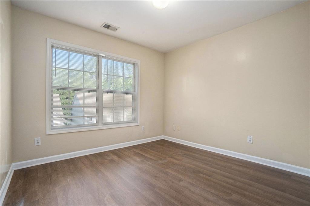 734 Celeste Lane, Unit 84 Atlanta, GA 30331 - Photo 18 of 34 an empty room with wooden floor and windows