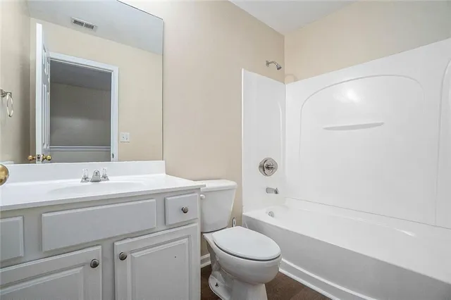 a bathroom with a sink toilet vanity and tub