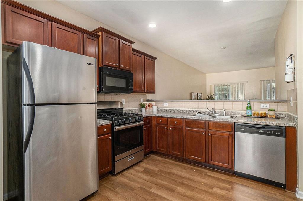 734 Celeste Lane, Unit 84 Atlanta, GA 30331 - Photo 10 of 34 a kitchen with stainless steel appliances granite countertop a refrigerator stove a sink and a microwave