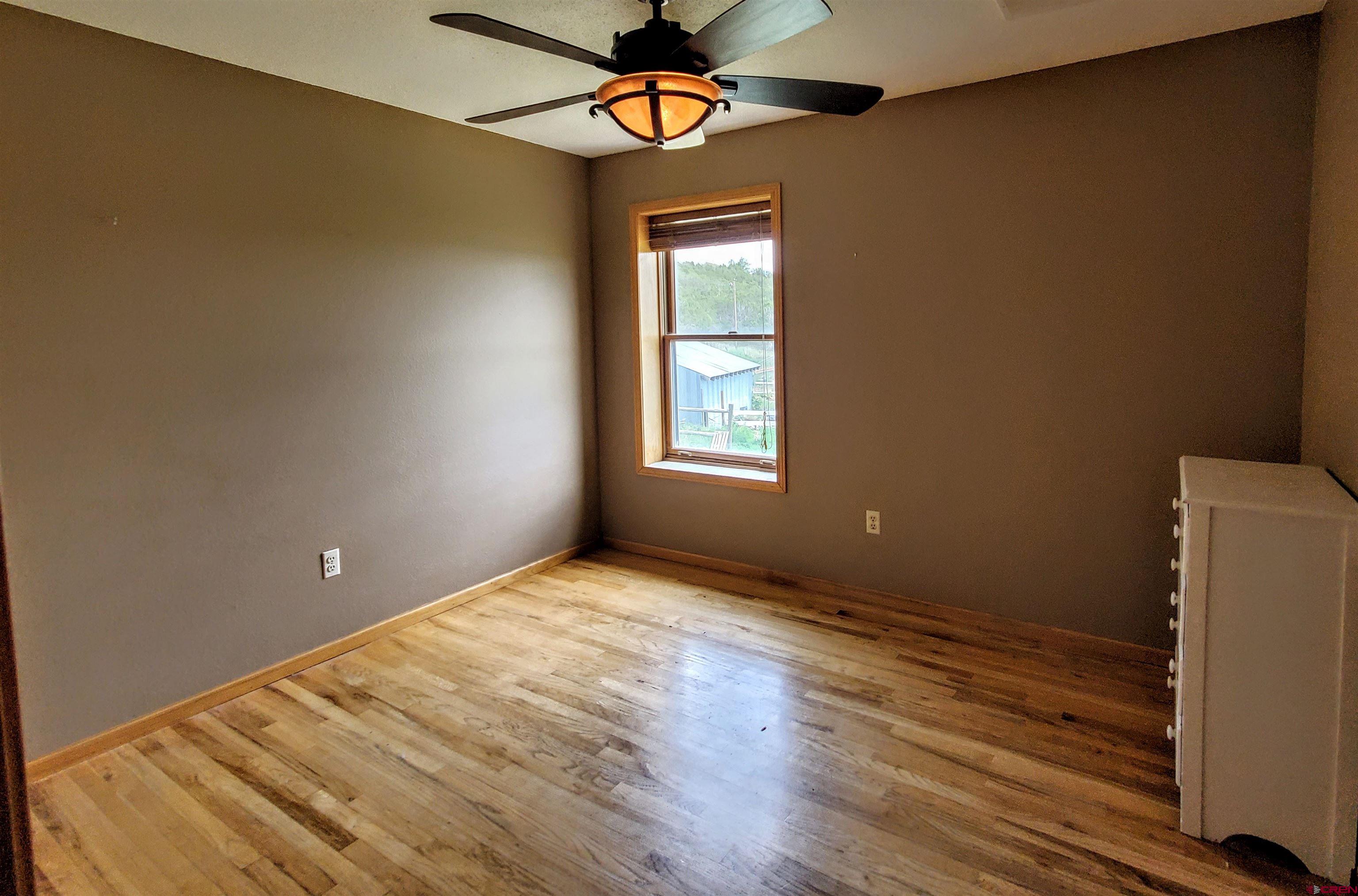 79 Cedar Circle Durango, CO 81303 - Photo 24 of 30 a view of an empty room with window and wooden floor
