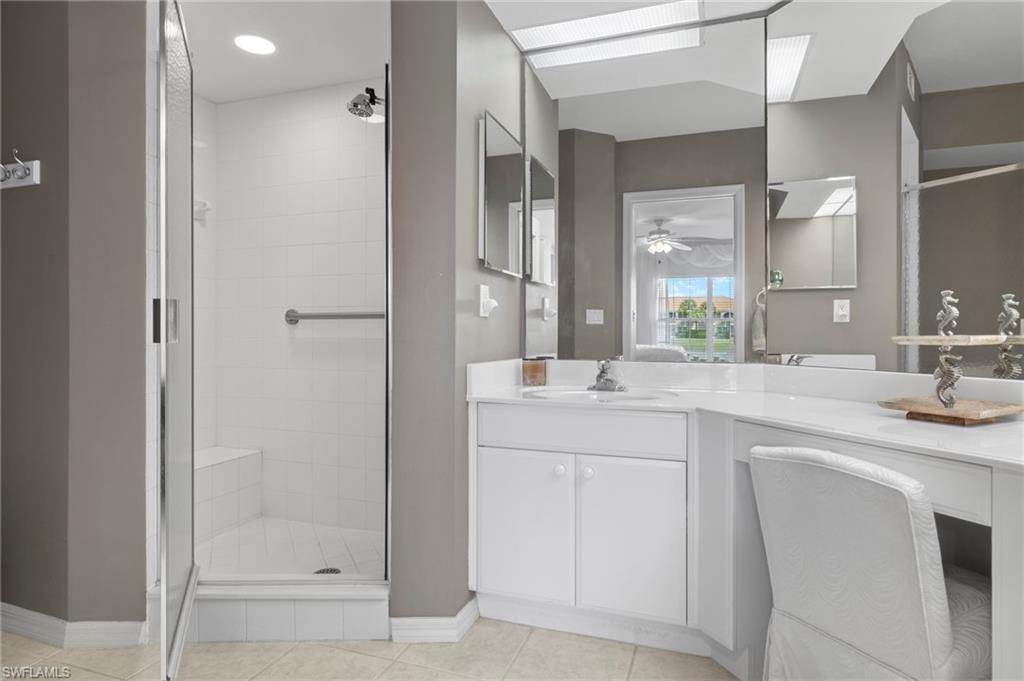 23821 Marbella Bay Road, Unit 102 Estero, FL 34135 - Photo 11 of 30 a bathroom with a shower sink and mirror