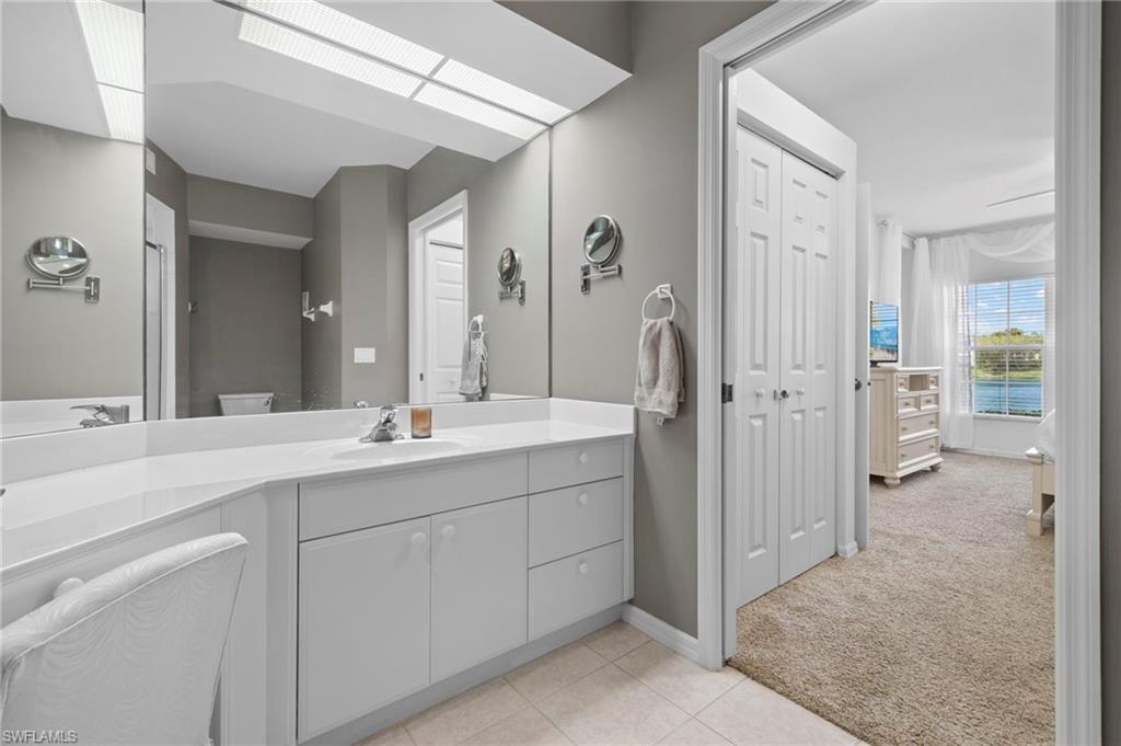 23821 Marbella Bay Road, Unit 102 Estero, FL 34135 - Photo 12 of 30 a bathroom with a shower sink and mirror