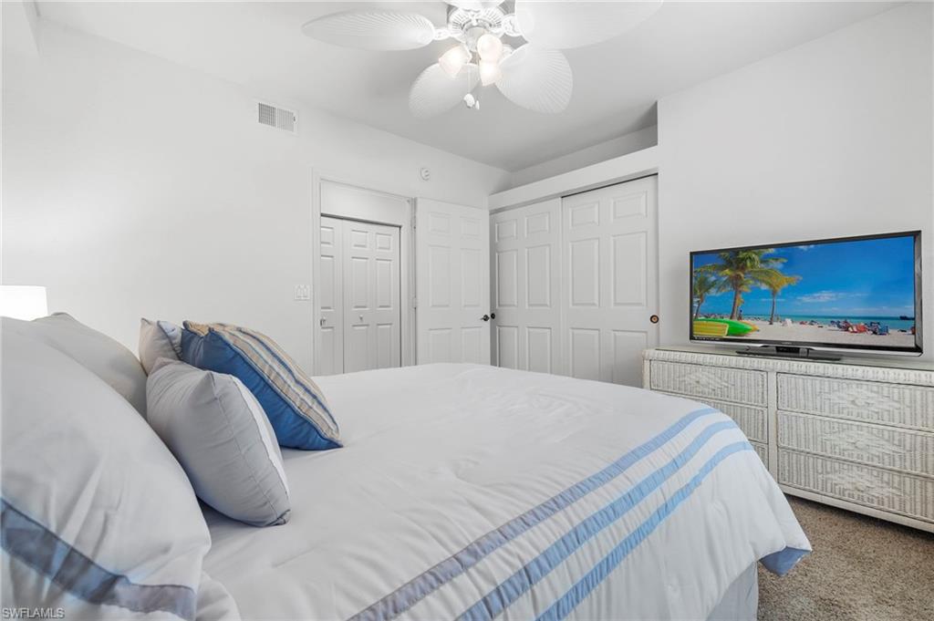 23821 Marbella Bay Road, Unit 102 Estero, FL 34135 - Photo 14 of 30 a bedroom with a bed and a flat screen tv