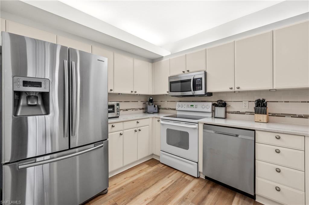 23821 Marbella Bay Road, Unit 102 Estero, FL 34135 - Photo 2 of 30 a kitchen with cabinets stainless steel appliances and a window