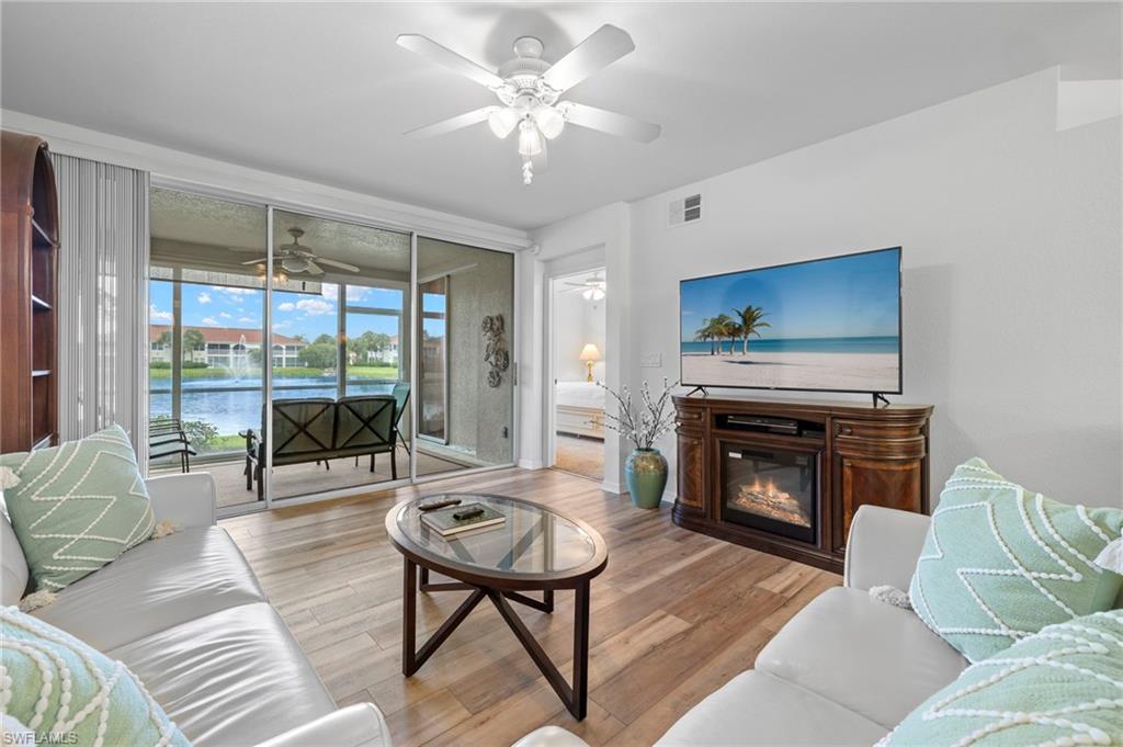 23821 Marbella Bay Road, Unit 102 Estero, FL 34135 - Photo 5 of 30 a living room with furniture a fireplace and a flat screen tv
