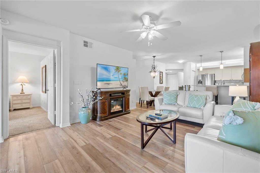 23821 Marbella Bay Road, Unit 102 Estero, FL 34135 - Photo 6 of 30 a living room with furniture a fireplace and a view