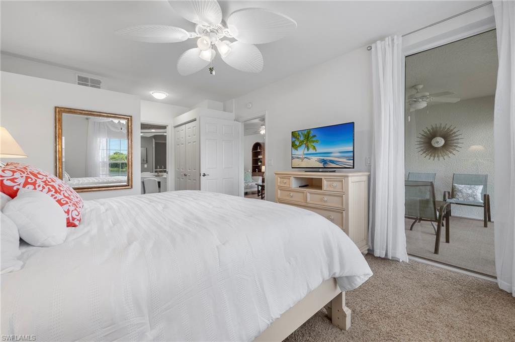 23821 Marbella Bay Road, Unit 102 Estero, FL 34135 - Photo 10 of 30 a spacious bedroom with a large bed and a chandelier