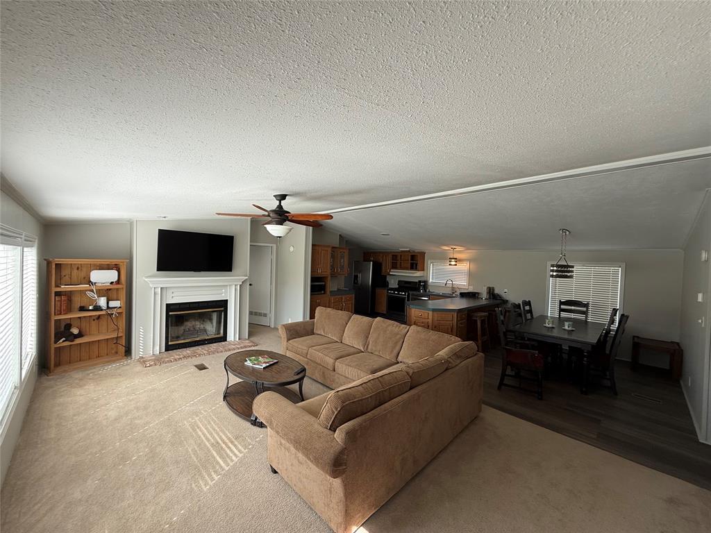 277 Oaks Crossing Road Mineral Wells, TX 76067 - Photo 7 of 25 a living room with furniture a fireplace and a flat screen tv