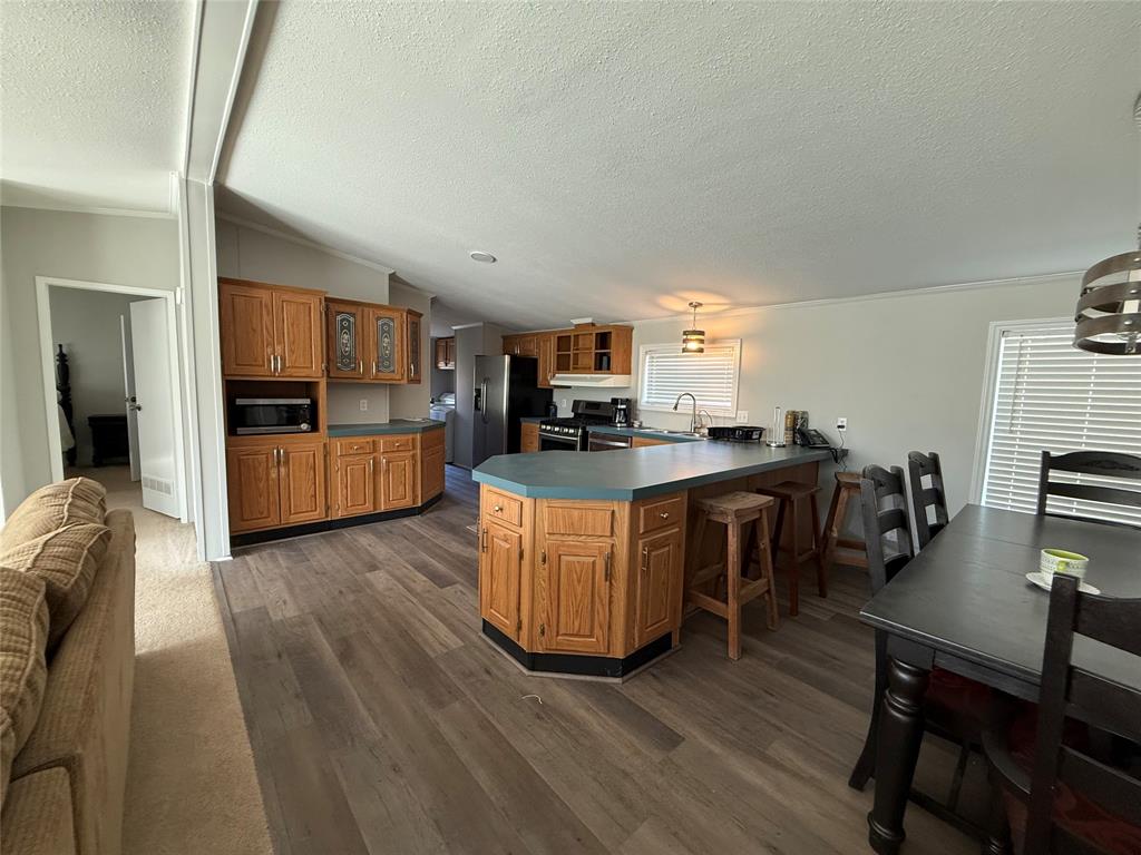 277 Oaks Crossing Road Mineral Wells, TX 76067 - Photo 8 of 25 a large kitchen with cabinets wooden floor and stainless steel appliances