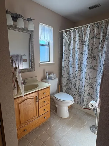 a bathroom with a granite countertop toilet sink and mirror
