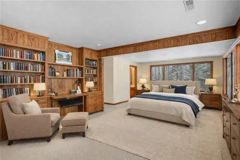 a spacious bedroom with a bed furniture and a book shelf