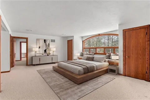 a spacious bedroom with a bed and a large window