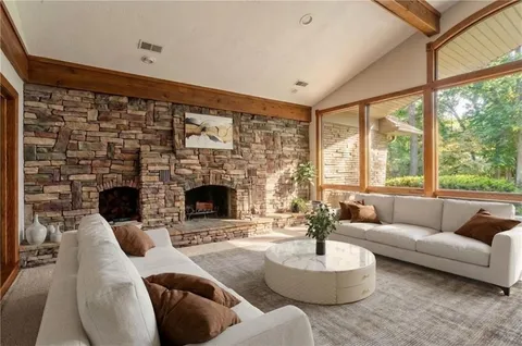 a living room with furniture a fireplace and a large window