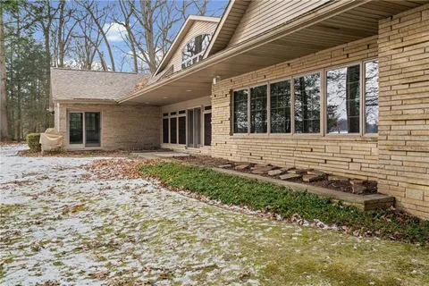 a front view of a house with a yard covered with snow